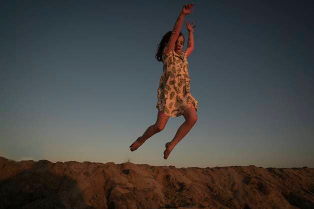 Creative Highlights Symbolbilder A 5-year-old girl in a dress jumps on a beach at sunset. Cabo San Lucas, Baja California Sur, Mexico CR_AXTH241102-1559803-01 ,model released, Symbolfoto