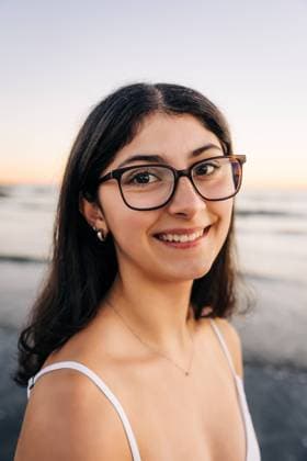 Creative Highlights Symbolbilder Smiling woman in glasses enjoying a beach at sunset Gloucester, Massachusetts, United States CR_FKNH241030-1571751-01 ,model released, Symbolfoto