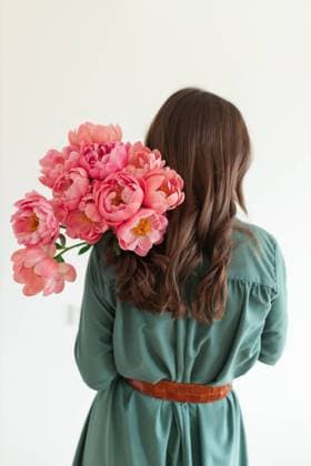 Creative Highlights Symbolbilder From Behind closeup of a pretty girl in a teal dress holding flowers Tallinn, Harju County, Estonia CR_GHEW241028-1571107-01 ,model released, Symbolfoto