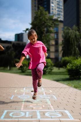 IMAGO Creative, Lifestyle, Frühling in der Stadt Girls playing hopscotch in the yard in the summer Minsk, Minsk Region, Belarus CR_YUKI241028B-1521942-01 EDITORIAL USE ONLY