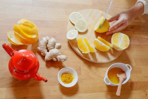 Hands cutting lemon, ginger, turmeric and honey tea ingredients Budapest, Hungary R_KSPY241112-1579999-01 ,model released, Symbolfoto