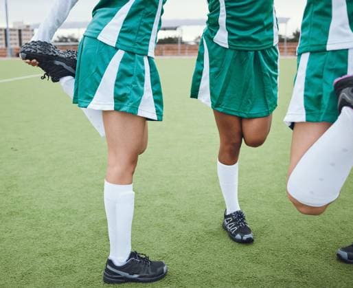 Team, stretching legs and fitness on field, sports and uniform for match, balance and teamwork together. Diverse group of athletes, outdoor and exercise to prepare for game, workout for performance. model released property released Copyright: xwww.peopleimages.comx