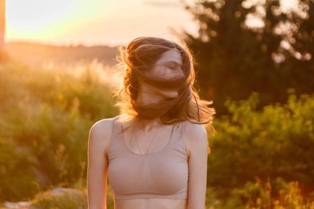 Creative Highlights Symbolbilder young woman joyfully waving her hair at sunset in the middle of nature Ukrainka, Kyiv Oblast, Ukraine R_ORFI210722-795106-01 ,model released, Symbolfoto