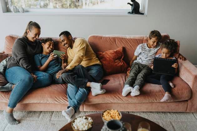 IMAGO Creative, Winter, Couching High angle view of multiracial happy family using wireless technologies while sitting on sofa at home Sweden, Stockholm, model released, property released Copyright: xMaskotx , MA113077 MA113077
