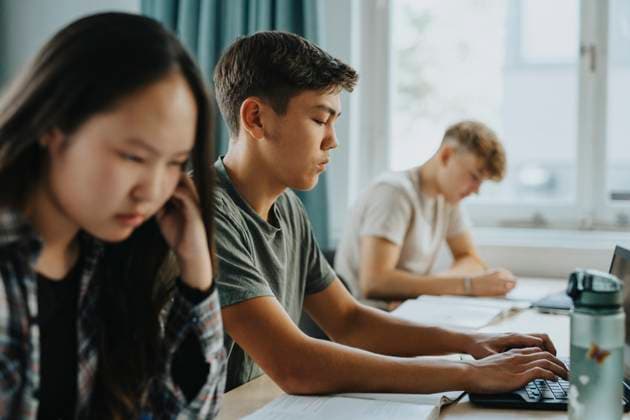 Teenage boy typing while using laptop by girl sitting at desk in classroom Sweden, Gothenburg, model released, property released Copyright: xMaskotx , MA113357 MA113357