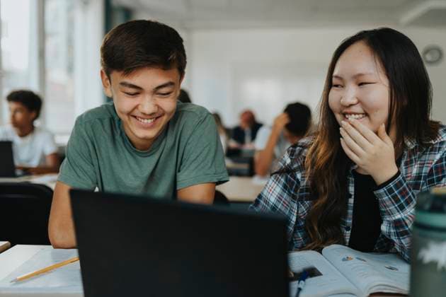Happy teenage boy and girl using laptop while sitting together in classroom Sweden, Gothenburg, model released, property released Copyright: xMaskotx , MA113361 MA113361