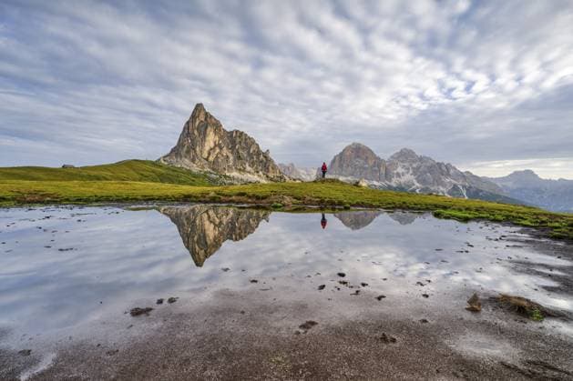 Spiegelung der Berge am Passo di Giau, Monte Ragusela, Frau mit rotem Rucksack, Dolomiten, Cortina d Ampezzo, Belluno, Venetien, Italien, Europa Reflection of the mountains at Passo di Giau, Monte Ragusela, woman with red rucksack, Dolomites, Cortina d Ampezzo, Belluno, Veneto, Italy, Europe Copyright: imageBROKER HannesxBrandstätter iblhab11789346.jpg