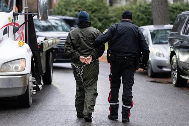 November 21, 2024, Ottawa, On, Canada: A Greenpeace climate activist (name not provided) is escorted to an Ottawa Police Service cruiser by an officer after being arrested for taking part in a sit-in styled protest calling for greater climate change awareness by Conservative Leader Pierre Poilievre, outside of Stornoway, the official residence of the country s official opposition, in Ottawa, on Thursday, Nov. 21, 2024. Ottawa Canada - ZUMAc35_ 20241121_zaf_c35_009 Copyright: xSpencerxColbyx