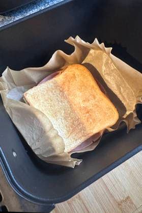 Gebackener Toast in der Heißluftfritteuse , Deutschland, 21.11.2024, Frisch gebackener Toast auf Backpapier, zubereitet in einer Heißluftfritteuse. Perfekt für einfache und schnelle Snack-Ideen im Alltag. *** Baked toast in the hot air fryer , Germany, 21 11 2024, Freshly baked toast on baking paper, prepared in a hot air fryer Perfect for quick and easy everyday snack ideas