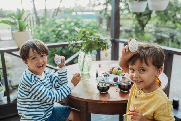 Brothers showing colorful easter eggs on front porch model released, Symbolfoto, ANAF04080