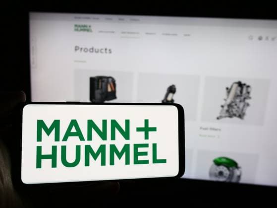 August 5, 2024, Germany: In this photo illustration, a person holds a mobile phone with the logo of German company Mann Hummel International GmbH Co. KG in front of web page. Germany - ZUMAs197 20240805_aaa_s197_195 Copyright: xTimonxSchneiderx