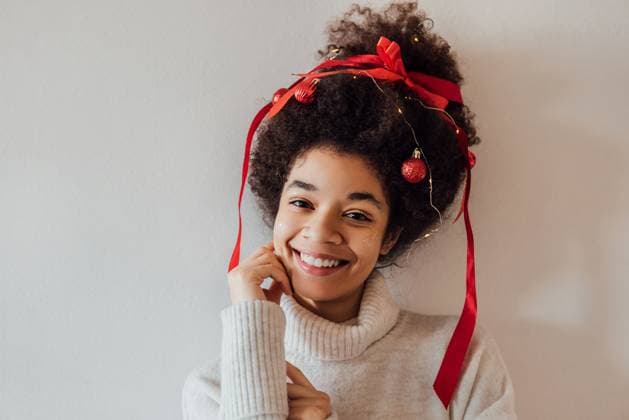 Creative Highlights Symbolbilder Nahaufnahme einer jungen Afrikanerin mit lockiger Frisur, geschmückt mit roter Schleife, Girlande und Weihnachtskugeln Close-up of young African with curly hairstyle decorated with red ribbon, garland and Christmas balls. Cute black girl in warm sweater is getting ready for New Year party. Woman is enjoying holiday ,model released, Symbolfoto Copyright: xZoonar.com DashaxPetrenkox 22303693 ,model released, Symbolfoto ,property released