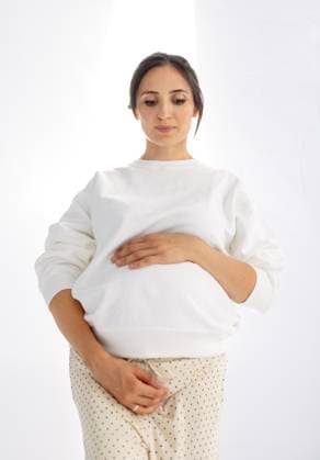 Creative Highlights Symbolbilder Eine elegante schwangere Frau hält sich sanft ihren Bauch. Die werdende Mutter berührt ihren Bauch A stylish pregnant woman gently holds onto her belly. The expectant mother touches her tummy against the background of a white wall. Bright sunlight. An attractive lady waiting for a baby indoors ,model released, Symbolfoto Copyright: xZoonar.com DashaxPetrenkox 22306518 ,model released, Symbolfoto ,property released