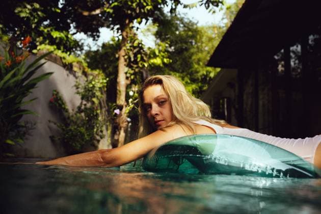 Creative Highlights Symbolbilder Happy woman relaxing on inflatable ring at pool during sunny day Kuta, Bali, Indonesia CR_YUKI241125-1577128-01 ,model released, Symbolfoto