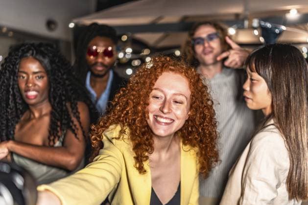 Glückliche elegante diverse Freunde nehmen Selfie in einer Terrasse während der Nacht Partei mit Lichtern schmücken den Hintergrund Happy elegant diverse friends taking selfie in a terrace during night party with lights decorating the background Copyright: imageBROKER UnaixHuizi ibxuhu11814452.jpg ,model released, Symbolfoto ,property released