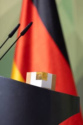 28.11.2024, Preis Bundeswehr und Gesellschaft Preisverleihung 2024 im Paul Löbe Haus des Deutschen Bundestags in Berlin. Rednerpult mit Preis, dahinter die Deutschland-Flagge. Berlin