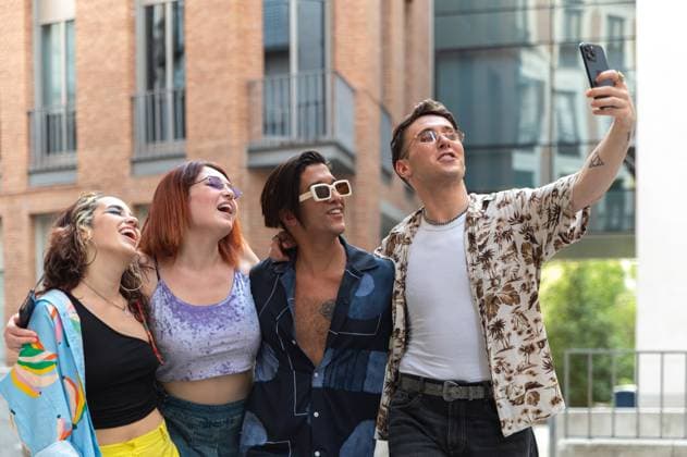 IMAGO Creative, Diversity, Teenager: LGBTQIA+ Four joyful friends sharing a fun moment while taking a selfie together on a bustling city street, radiating happiness and camaraderie. Model Released DavidPrado_ID25521_737736_027 Copyright: xDavidxPradox