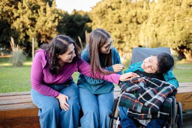 A heartwarming scene of a loving Latin family in a park Two women engage warmly with a child in a wheelchair, showcasing connection, care, and joy in a sunny, natural setting Model Released Padnob_ID22345_652603_040 Copyright: xPadnobx RECORD DATE NOT STATED