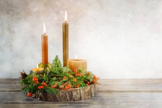 Vier Variationen von Kerzen mit naturgrünen Zweigen und orangefarbenen Beeren auf einer Baumscheibe als Advents- und Weihnachtsdekoration, rustikale beige Hintergrundwand mit Kopierfläch Four variations of candles with natural green branches and orange berries on a slice of tree as an Advent and Christmas decoration, rustic beige background wall with copy space, selected soft focus Copyright: xZoonar.com maren-winter.dex 22322517