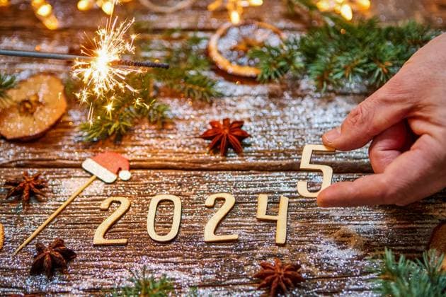 7 December 2024: Turn of the year from 2024 to 2025. A hand inscribes the wooden number 5, while a lit sparkler and sparkling decorations symbolize the new year *** Jahreswechsel von 2024 zu 2025. Eine Hand fügt die Holz-Zahl 5 ein, während eine brennende Wunderkerze und funkelnde Dekorationen das neue Jahr symbolisieren