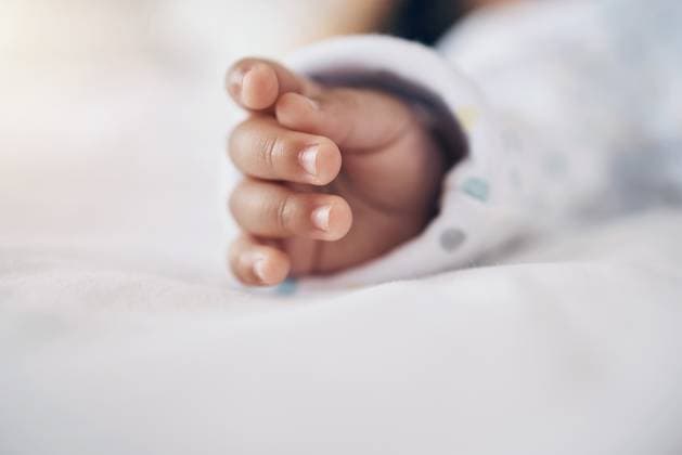 Creative Highlights Symbolfotos Baby, sleeping and closeup of hands on bed for child development, growth and comfortable in nursery. Newborn, tired and rest in home for morning routine, nap and dreaming with wellness and security. model released property released Copyright: xwww,peopleimages.comx