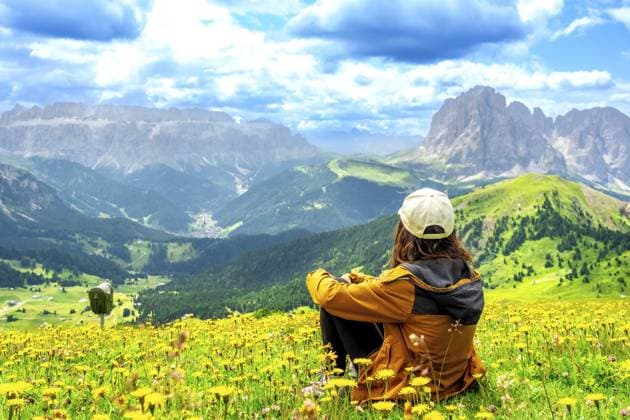 Wanderer, der im Sommer die atemberaubende Aussicht auf die Seceda Berge in den Dolomiten genießt, umgeben von bunten Wildblumen Hiker enjoying the stunning view of the seceda mountains in the dolomites during summer, surrounded by colorful wildflowers Copyright: imageBROKER UnaixHuizi ibxuhu11903688.jpg ,model released, Symbolfoto ,property released