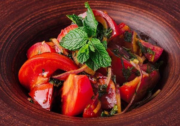 Traditioneller georgischer Salat auf rustikalem Geschirr Vibrant georgian salad in a clay bowl, garnished with fresh herbs close up Copyright: xZoonar.com AntonxDobreax 22331729