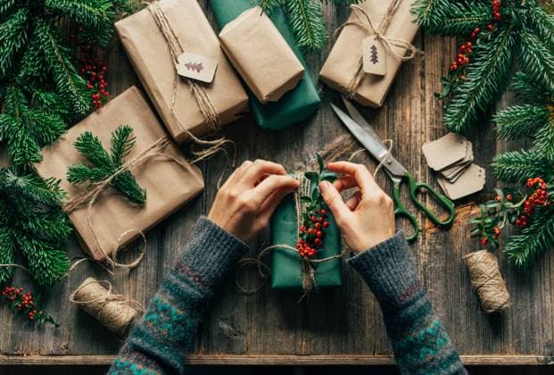 Die Hände einer nicht erkennbaren Frau verpacken Weihnachtsgeschenke auf dem Tisch in einer Kreativwerkstatt. The hands of an unrecognizable woman wrap Christmas gifts on the table in a creative workshop. ,model released, Symbolfoto Copyright: xZoonar.com TITOVAxILONAx 22370855 ,model released, Symbolfoto ,property released