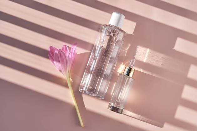 IMAGO Creative, Naturkosmetik Flasche mit Gesichtswasser oder Reinigungsmittel auf einem rosa Hintergrund mit Streifen Schatten. Flasche mit Gesichtswasser oder Reinigungsmittel auf einem rosa Hintergrund mit Streifen Schatten. Copyright: xZoonar.com MAREVGENNAx 22458617