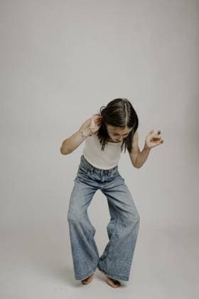 Creative Highlights Symbolfotos Dunkelhaariges Mädchen, 10, in Blue Jeans, macht einen lustigen Move.jpg Dark-haired girl, 10, in blue jeans, making a funny move.jpg Copyright: imageBROKER MichaelaxBegsteiger ibxbeg11923442.jpg ,model released, Symbolfoto ,property released