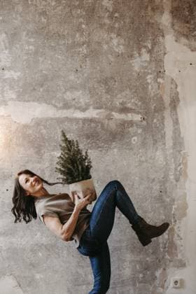 Dynamische Frau vor grauer Betonwand mit einem kleinen Tannenbaum in der Hand Dynamic woman in front of a grey concrete wall with a small Christmas tree in her hand Copyright: imageBROKER MichaelaxBegsteiger ibxbeg11923398.jpg ,model released, Symbolfoto ,property released