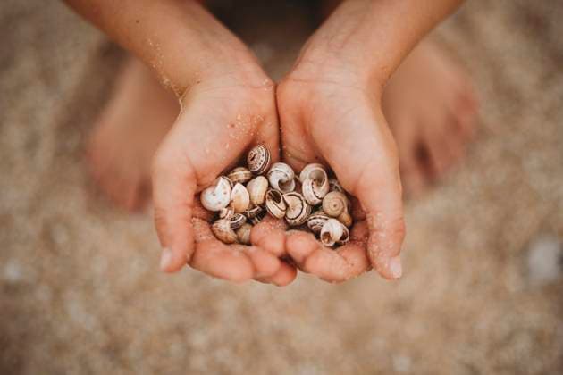 Creative Highlights Symbolfotos Close up of child hands full of sand holding a rock Cádiz, Andalusia, Spain CR_TANI241216-1581640-01 ,model released, Symbolfoto