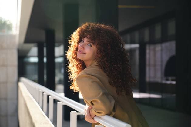 Creative Highlights Symbolfotos Smiling businesswoman with curly red hair leaning on railing Madrid, Community of Madrid, Spain CR_CRVI241217-1599078-01 ,model released, Symbolfoto
