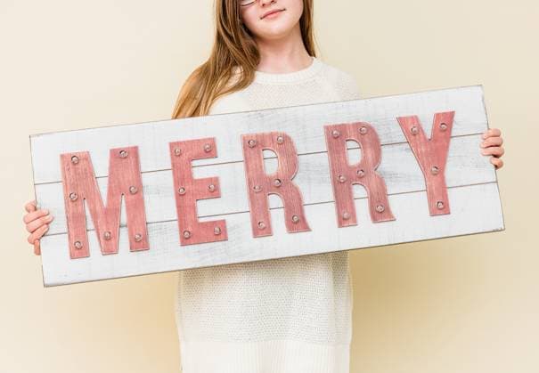 Creative Highlights Symbolfotos Woman Holding Rustic Christmas Sign Punta Gorda, Florida, United States R_AHPQ241216-1604216-01 ,model released, Symbolfoto