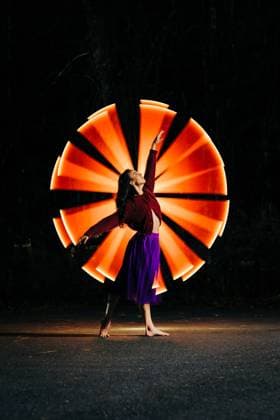Creative Highlights Symbolfotos Woman in purple skirt posing in front of radiant orange light beams Sudbury, Massachusetts, United States R_FKNH241217-1603401-01 ,model released, Symbolfoto