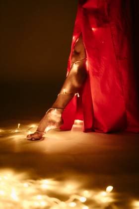 Creative Highlights Symbolfotos Close-up of a bare foot wrapped in glowing lights under a red dress Sudbury, Massachusetts, United States R_FKNH241217-1603431-01 ,model released, Symbolfoto