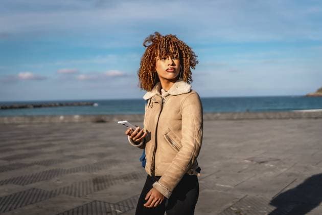 Schöne lateinische junge Frau, die einen Spaziergang auf der Promenade genießt und dabei ihr Handy benutzt Beauty latin young woman enjoying walk in the promenade using mobile phone Copyright: imageBROKER UnaixHuizi ibxuhu11958364.jpg ,model released, Symbolfoto ,property released