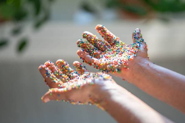 Hand bedeckt in bunten Backen Streuungen für Donuts, Kuchen, süße Desserts und Ostern Cupcake. Hand bedeckt in bunten Backen Streuungen für Donuts, Kuchen, süße Desserts und Ostern Cupcake. Copyright: xZoonar.com DmitriixMarchenkox 22515754