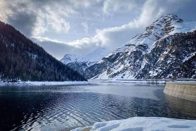 Scenic view of Lago di Livigno with Punt dal Gall arch dam in winter Scenic view of Lago di Livigno with Punt dal Gall arch dam in winter against blue sky with clouds Copyright: xZoonar.com FabianxMesebergx 22524945