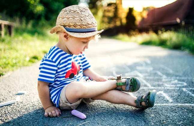 Creative Highlights Symbolbilder Toddler boy sitting on the street taking off his shoes model released, Symbolfoto, HAPF02750