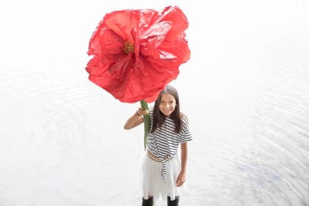 Creative Highlights Symbolbilder Portrait of smiling girl standing in a lake holding oversized red artificial flower model released, Symbolfoto, PSTF00204