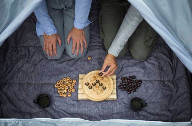Creative Highlights Symbolbilder Couple sitting in tent playing board game, partial view model released, Symbolfoto, JPTF00014