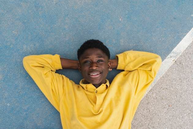 Creative Highlights Symbolbilder Young black man lying on floor, with hands behind head model released, Symbolfoto, AFVF01803