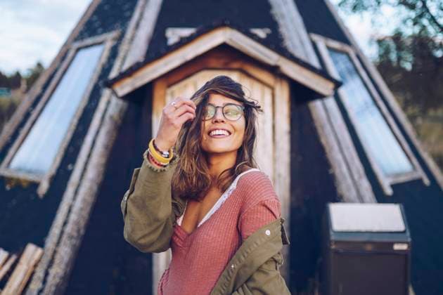 Creative Highlights Symbolbilder Portrait of a laughing young woman infront of a Finnish house model released, Symbolfoto, RSGF00103