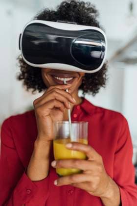 Creative Highlights Symbolbilder Woman standing in her kitchen, wearing VR goggles, drinking orange juice model released, Symbolfoto property released, BOYF01001