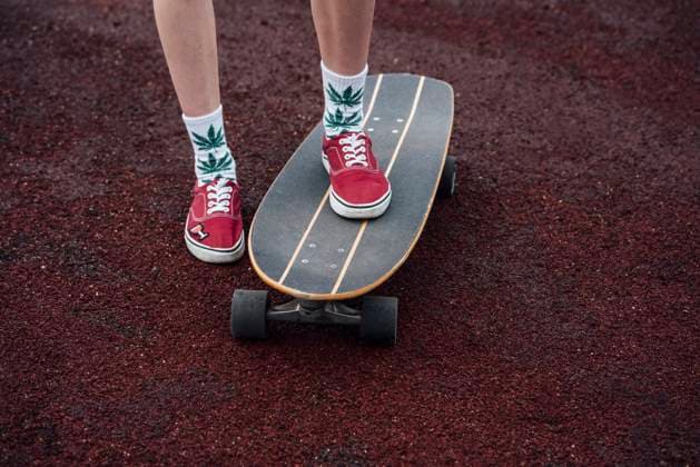 Creative Highlights Symbolbilder Woman s legs in socks and sneakers standing on carver skateboard model released, Symbolfoto, VPIF00971