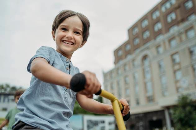 Creative Highlights Symbolbilder Happy boy riding bicycle near building model released, Symbolfoto, ANAF04288
