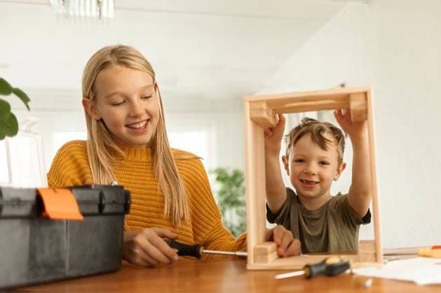 Creative Highlights Symbolbilder Happy boy helping sister assembling wooden crate with screwdriver at home model released, Symbolfoto property released, OSVF00252