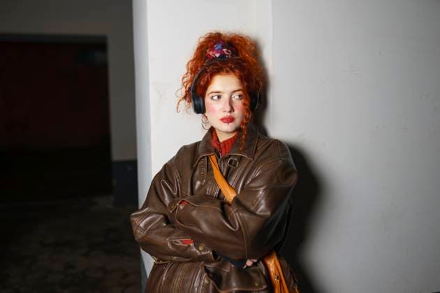 Creative Highlights Symbolbilder Redhead young woman wearing leather jacket and leaning on wall model released, Symbolfoto, VCF00498