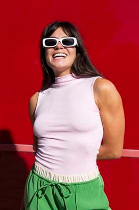 Creative Highlights Symbolbilder Smiling woman wearing sunglasses near red wall model released, Symbolfoto, LMCF01983